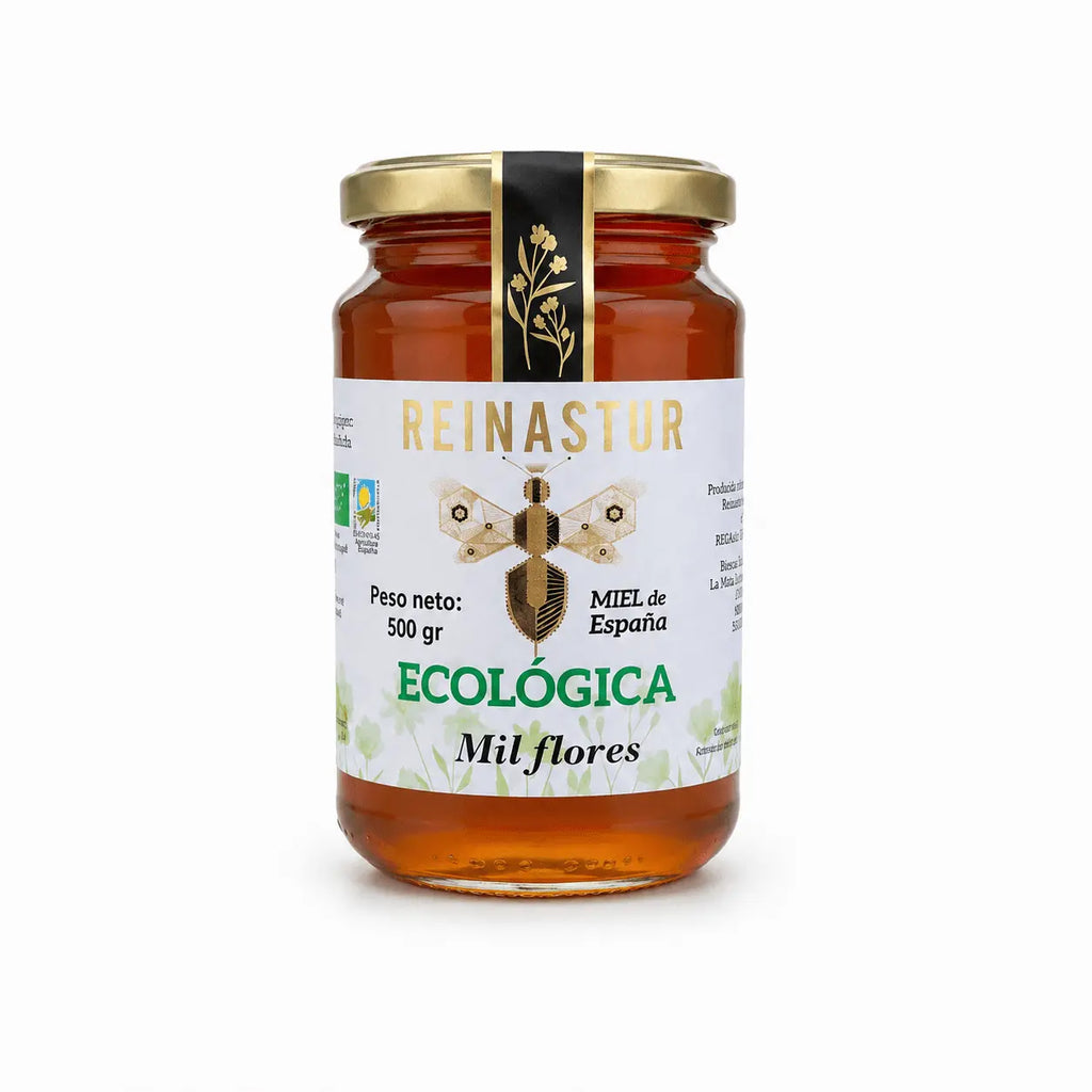 Tarro de 500 gramos de miel ecológica de Milflores Reinastur con tapa dorada y etiqueta blanca sobre fondo blanco.